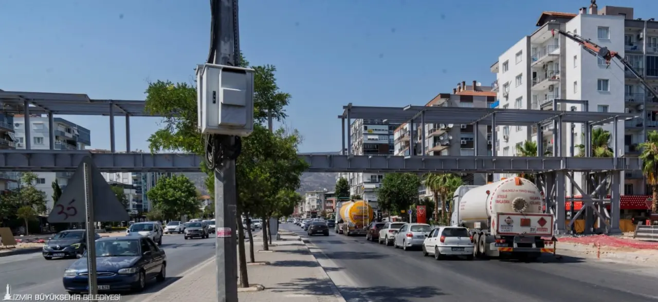 İzmir Büyükşehir Belediyesi güvenli ve konforlu ulaşım için Karşıyaka Yeni Girne Caddesi’ne yaya üst geçidi inşa ediyor. Gölgeliği, yayaların dinlenerek çevreyi seyredebileceği oturma alanları ile bölgeye renk katacak üst geçit ağustos ayı sonunda hizmete girecek. 