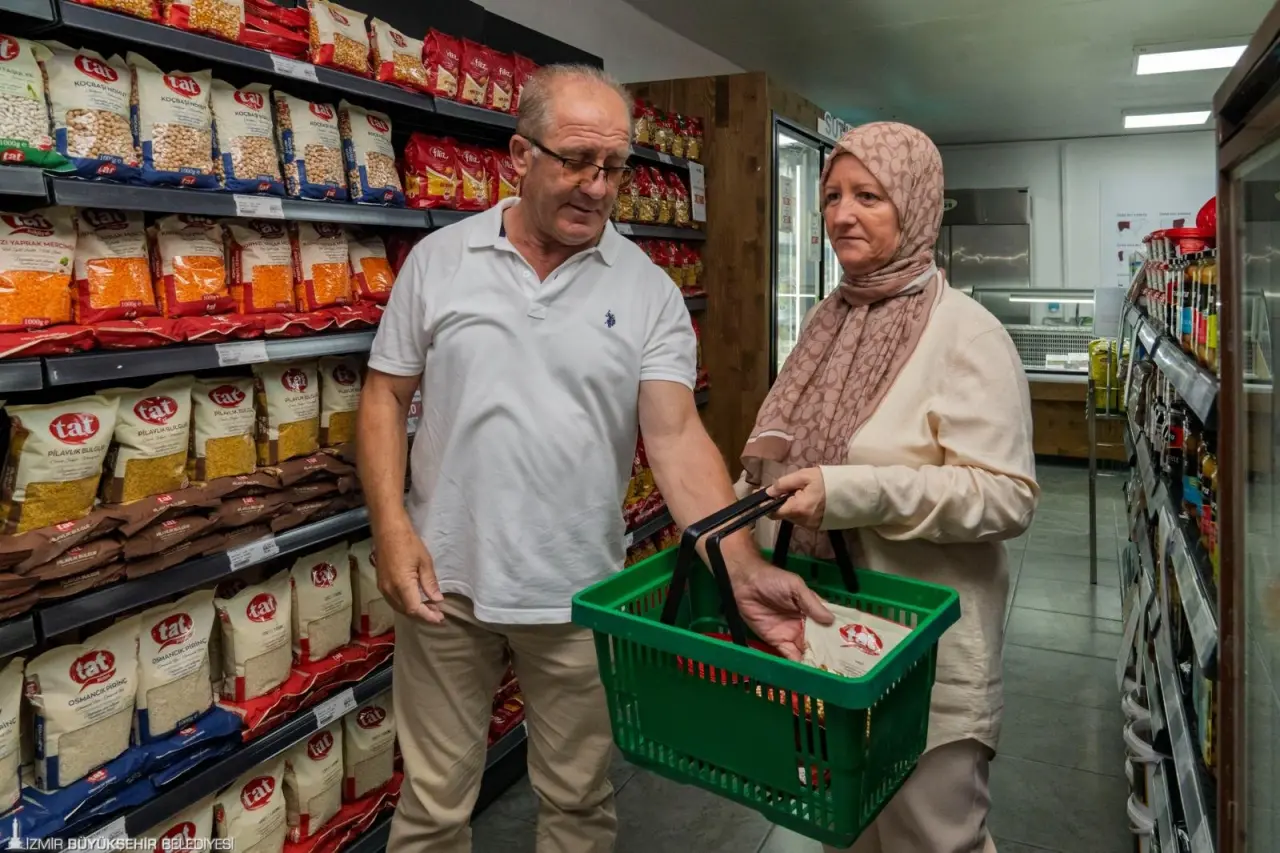 İzmir’in tanzim satış mağazaları İZMAR, 8’inci şubesini Bornova Erzene Mahallesi’nde hizmete açtı. Açıldığı günden beri İzmirlilerin yoğun ilgi gösterdiği mağazalar, vatandaşları güvenli ve uygun fiyatlı alışverişle buluşturmaya devam ediyor. İlk şubesi nisan ayında açılan İZMAR mağazaları, ülke genelinde artan fiyatlara rağmen zam yapmadan yoluna devam ediyor.