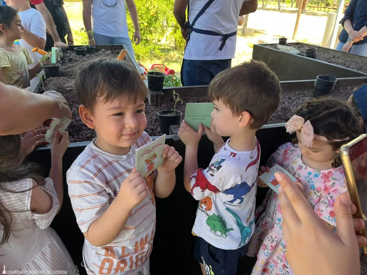 İzmir Büyükşehir Belediyesi, doğa bilincini her yaş grubuna yayma hedefiyle anaokulu öğrencilerini “Tohumdan Sofraya” etkinliğinde konuk etti. Minikler, domatesin tohumdan sofralara gelene kadar geçen sürecini uygulamalı gözlemledi.