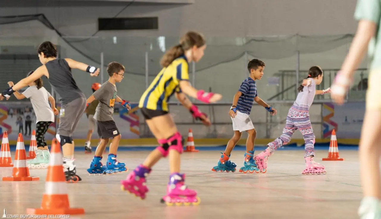 Yazın farklı spor branşlarında da hizmet sunulabilmesi amacıyla Bornova'daki Âşık Veysel Rekreasyon Alanı'nda bulunan Buz Sporları Salonu'nun zeminini yenileyen İzmir Büyükşehir Belediyesi’nin bu yıl ilk kez hayata geçirdiği tekerlekli paten kursları sürüyor. Çocuklar da veliler de eğitimden memnun.